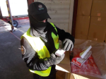 Funkcjonariusz  Służby Celno-Skarbowej otwiera karton z papierosami